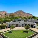 Elevated aerial view highlighting manicured landscaping, circular drive, and Camelback Mountain backdrop at this luxury Arcadia Proper home in Phoenix.