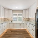 Impressive Butler s pantry with extensive storage, stone countertops, and integrated wine refrigeration for effortless organization.