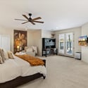 Oversized primary bedroom offering a private lounge area, soft carpeting, and calming finishes for a relaxing retreat.