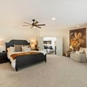 Thoughtfully designed primary suite with generous proportions, seating space, and access to a spa-inspired bathroom.