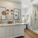 Primary bathroom featuring dual sinks, custom cabinetry, designer lighting, and upscale finishes throughout.