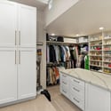 Custom walk-in closet with built-in shelving, center island, and ample space for clothing, shoes, and accessories.