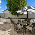 Inviting outdoor entertaining area with built-in BBQ, dining table, and privacy walls for year-round enjoyment in Phoenix.