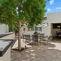 Charming outdoor courtyard with dining area, shade tree, and easy access to interior spaces perfect for relaxed Phoenix entertaining.