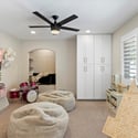 Guest bedroom with custom built-ins, ample storage, and plantation shutters providing versatility and everyday comfort.