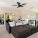 Comfortable loft space with plush carpet and ceiling fan, ideal for lounging, media use, or secondary living area.