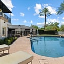 Resort-inspired pool featuring rock accents, clean lines, and lush greenery creating a relaxing outdoor atmosphere.