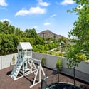 Well-designed outdoor play area with privacy walls, durable materials, and thoughtful placement within the backyard.
