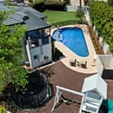 Aerial perspective showcasing the play structure, trampoline, and pool, highlighting the property s outdoor versatility.