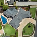 Bird s-eye view capturing the entire property, including the home, backyard amenities, lawn, and outdoor living features.