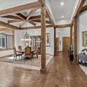 Elegant dining space featuring dramatic timber beams, upscale finishes, natural light, and a warm mountain-modern atmosphere ideal for hosting gatherings.