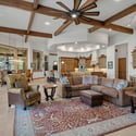 Spacious great room with dramatic timber beams, soaring ceilings, oversized fan, and warm mountain-inspired finishes ideal for entertaining guests and relaxing.