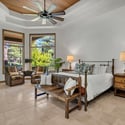 Spacious primary suite with vaulted ceilings, large windows, outdoor patio access, and serene pine forest views designed for luxury mountain living.