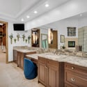 Elegant spa-inspired bathroom with dual sinks, custom cabinetry, granite countertops, designer lighting, and luxurious mountain-modern finishes throughout.