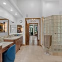 Spacious primary bath with glass block shower, premium stone details, dual vanity setup, and refined finishes designed for everyday comfort and luxury living.