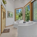 Private wellness area with infrared sauna, peaceful seating space, and large windows bringing natural light and forest views into the luxurious primary suite.
