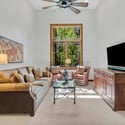 Dedicated office or flex room featuring vaulted ceilings, oversized windows, and a quiet sitting area ideal for working from home in Flagstaff.