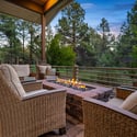 Cozy outdoor firepit gathering area overlooking multiple golf course fairways, perfect for entertaining or relaxing beneath the Flagstaff evening skies.