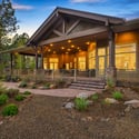 Gorgeous custom home exterior with timber beam accents, expansive covered patio areas, and beautifully landscaped grounds in the heart of Flagstaff.