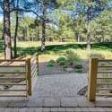 Charming backyard entrance opening to expansive fairway views, landscaped grounds, and peaceful forest surroundings in Flagstaff.