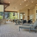 Spacious covered outdoor living area designed for entertaining with golf course views, multiple seating spaces, and beautiful natural surroundings.