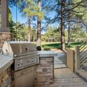 Built-in BBQ station with stone accents and scenic golf course surroundings, ideal for outdoor cooking and entertaining in Flagstaff.
