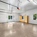 Oversized garage with custom cabinetry, generous storage options, bright windows, and ample room for hobbies, tools, and vehicles.
