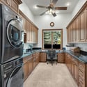 Spacious laundry room with extensive cabinetry, built-in workspace, granite counters, and exceptional storage solutions for everyday convenience.