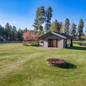 Spacious community park area with lush lawns, recreational amenities, and peaceful forest surroundings just moments from the property.