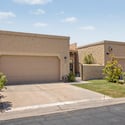 Front exterior view highlighting the oversized two-car garage, private gated entry, and attractive low-maintenance landscaping. This Scottsdale townhome offers convenience, privacy, and excellent curb appeal.