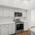 Updated kitchen showcasing crisp white shaker cabinets, stainless steel appliances, subway tile backsplash, and sleek countertops. The fresh design creates a bright and functional cooking environment.