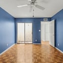 Well-sized bedroom with parquet flooring, ceiling fan, and bright natural light. This adaptable room adds flexibility to accommodate changing lifestyle needs.