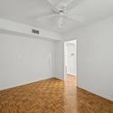 Flexible living space featuring parquet flooring, ceiling fan, and a neutral color palette. Ideal for a home office, craft room, guest quarters, or additional living area.