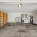 Large two-car garage offering extensive shelving, storage cabinetry, and room for projects or recreational equipment. A highly functional space with exceptional storage potential.