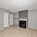 Comfortable living room centered around an updated fireplace feature wall. The open layout and neutral finishes provide a warm and inviting setting for family and guests.