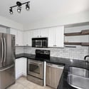 Bright kitchen with sleek countertops, stainless steel appliances, open shelving, and modern fixtures. Functional design and updated finishes create a welcoming heart of the home.