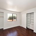 Well-designed primary bedroom featuring custom shelving, integrated storage solutions, and attractive flooring. Functional updates enhance organization and everyday convenience.