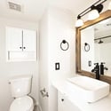 Freshly updated bathroom with contemporary fixtures, decorative mirror, and modern lighting. Neutral finishes and clean lines create a polished appearance.
