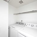Dedicated laundry room with full-size appliances, overhead shelving, and extra storage capacity. Designed to make daily household tasks simple and efficient.