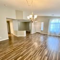 Open and airy great room featuring updated flooring, soaring natural light, and flexible living space. Perfect for entertaining guests or enjoying everyday comfort.