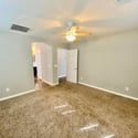 Comfortable owner's suite featuring generous dimensions, natural light, and soft carpeting. The split-bedroom layout enhances privacy and functionality throughout the home.
