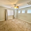 Inviting secondary bedroom offering soft carpeting, neutral finishes, ceiling fan comfort, and natural light. A flexible space perfect for guests, family, or remote work needs.