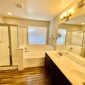 Elegant primary bathroom showcasing dual sinks, separate shower, soaking tub, and spacious vanity. A private retreat designed to complement the home's comfortable lifestyle.
