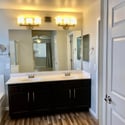 Large dual-sink vanity with abundant counter space, upgraded cabinetry, and modern lighting. This thoughtfully designed bathroom offers convenience and everyday functionality.