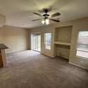 Open living and dining area featuring large windows, backyard views, and direct patio access. Built-in media space adds convenience and flexibility for modern living.