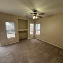 Comfortable family room with a built-in niche, plush carpeting, and multiple windows that bring in natural light. An excellent setting for movie nights, gatherings, or quiet evenings at home.