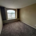 Flexible bonus room with a large arched window, plush carpeting, and built-in media niche. An excellent option for a game room, office, reading area, or entertainment lounge.