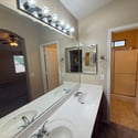 Spacious primary bathroom showcasing dual vanities, expansive mirrors, and convenient access to the shower area. Ideal for busy mornings and shared routines.