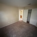 Comfortable bedroom with neutral d cor, plush carpeting, and convenient closet storage. A versatile space suitable for family, guests, or a home office setup.