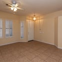 Comfortable living area with large windows, plantation shutters, and durable tile flooring. A welcoming space that blends functionality and elegance near the home's main entry.